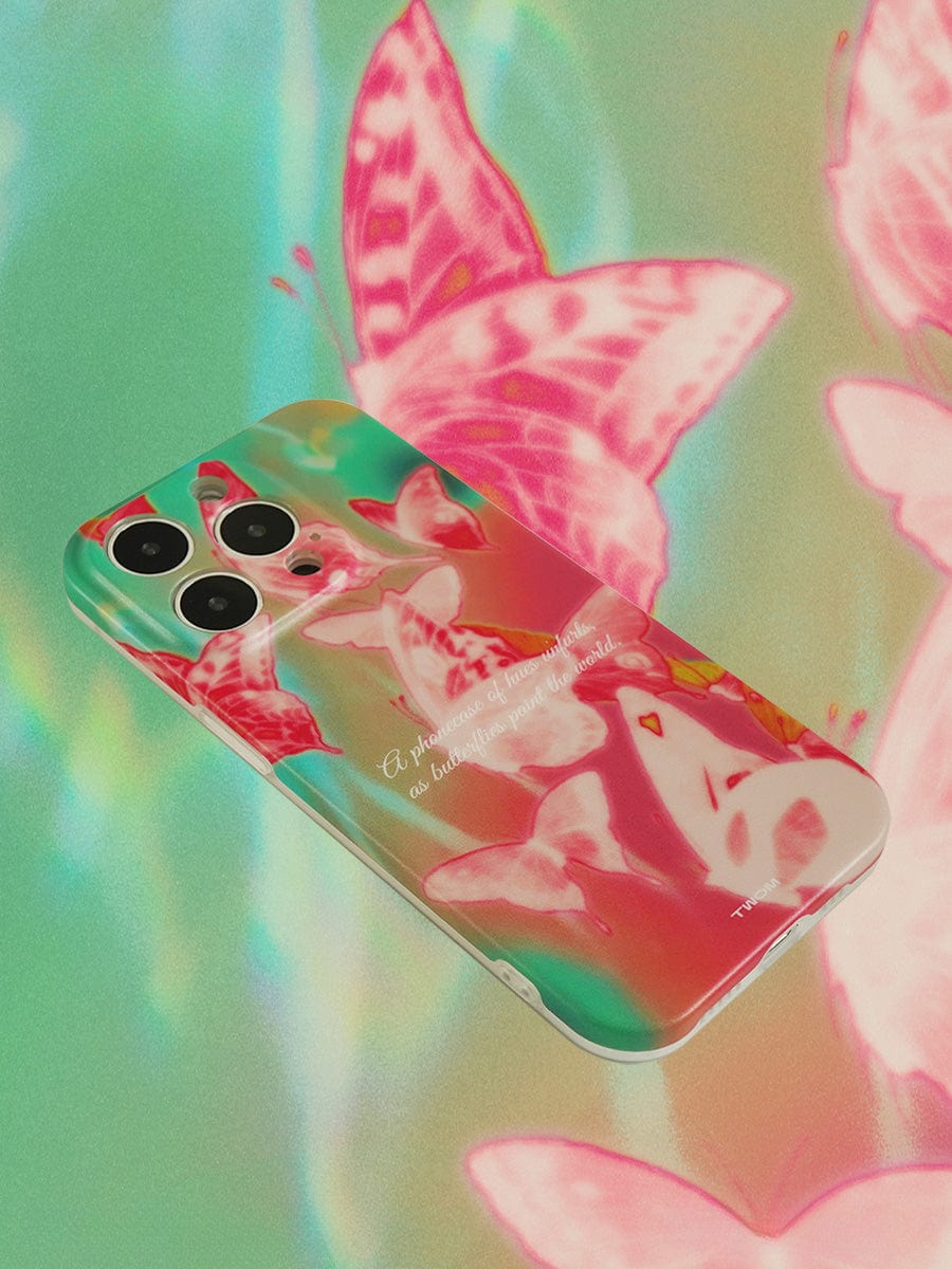 An iPhone 16 Pro Max encased in a Butterfly Dreamscape iPhone 16 Pro Max Case, showcasing vibrant pink, green, and red hues with abstract butterfly designs and a quote in white text, rests on a shimmering surface adorned with matching butterfly prints.