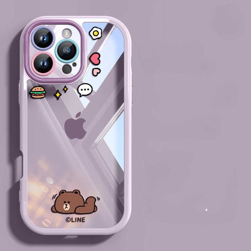 This iPhone 16 Pro Max Case is a Cute Cartoon Clear Protective Cover with a shockproof bumper and anti-yellowing transparent back, featuring a cartoon bear, stars, and various small icons on the back. The phone has three cameras and a light purple border. The background showcases a blurred window scene.