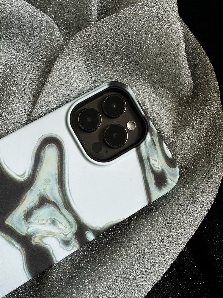 The Abstract Metallic Flow iPhone 16 Pro Max Case, featuring a sleek modern art design, cradles the device as it rests on a textured, shiny metallic fabric. The phone's camera lenses are prominently visible.