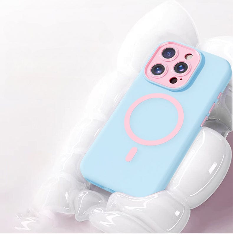 An iPhone 16 Pro Max encased in a blue and pink Soft TPU Liquid Silicone MagSafe Protective Cover with Nano Cushion Technology, showcasing a circular design, rests on a soft, white, cloud-like surface.