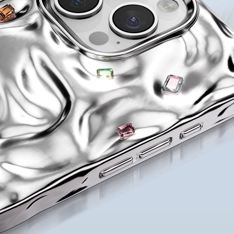 A close-up of the iPhone 16 Pro Max Luxury Case showcases its silver finish with a wrinkled texture, highlighted by Artisanal gemstone decor and visible camera lens cutouts, while providing robust dual-layer protection.