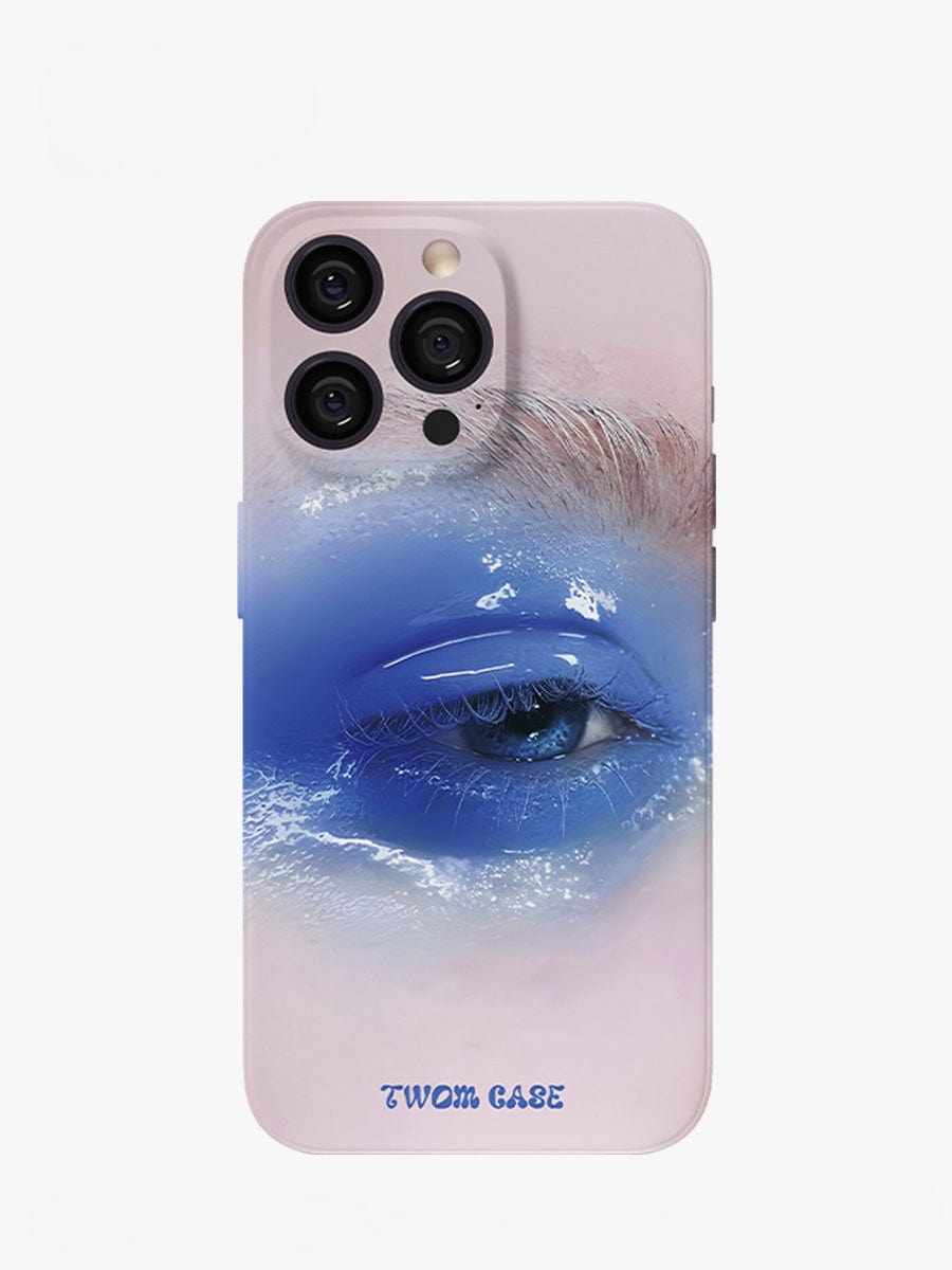 Introducing the Dreamy Blue Eye iPhone 16 Pro Max Case, a surreal art design that features a close-up image of a blue eye adorned with dramatic makeup, including layered hues of blue and white and striking white eyelashes. The black-edged case enhances its elegance, with "TWOM CASE" elegantly printed in blue lettering at the bottom.