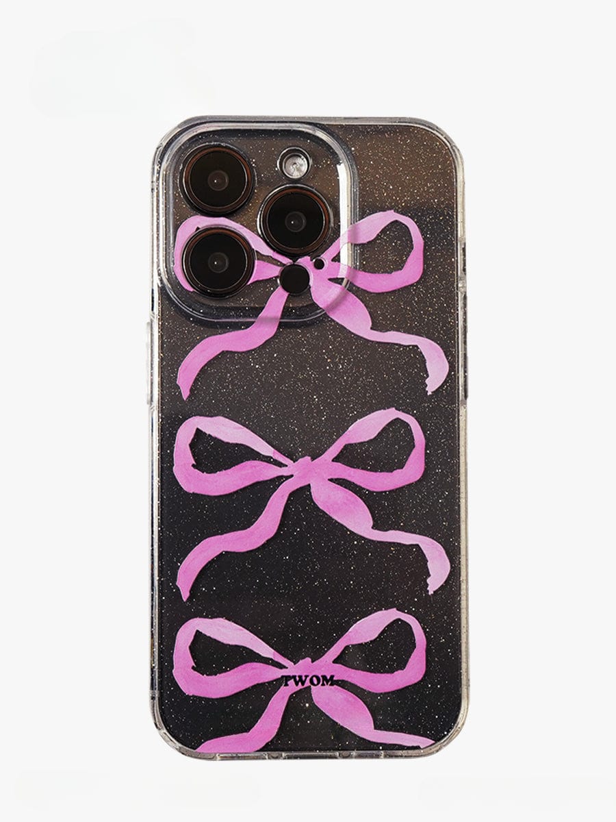 The Pink Ribbon Bow Transparent iPhone 16 Pro Max Case features a sparkling clear design with three vertically arranged pink ribbon bows. The transparent areas reveal the phone's camera lenses at the top, while the bottom displays the word "TWOM" in black.