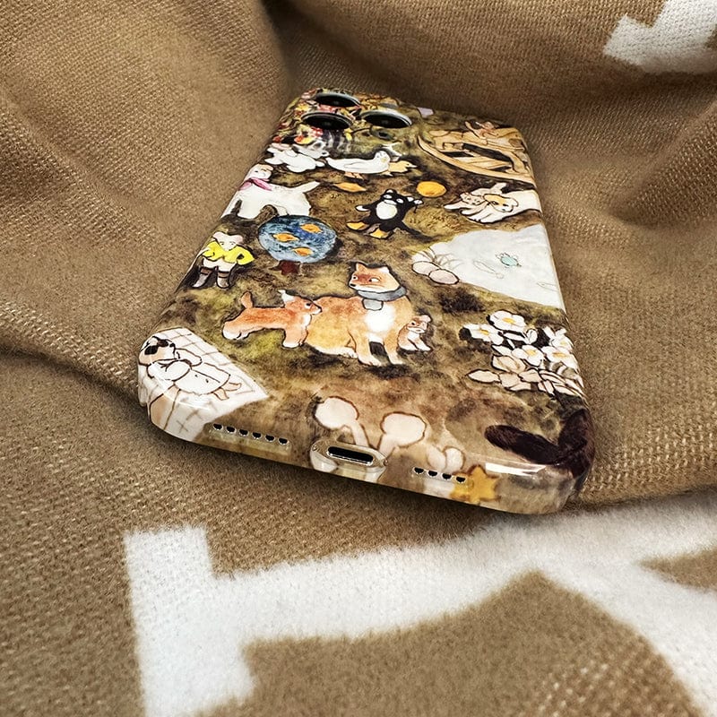 A close-up of an iPhone 16 Pro Max adorned with the "Charming Woodland Animals iPhone 16 Pro Max Case - Whimsical Nature Scene, Ultra-Slim, Durable Protection," showcasing colorful illustrations of foxes, penguins, and rabbits. The phone is resting on a soft, brown patterned blanket.