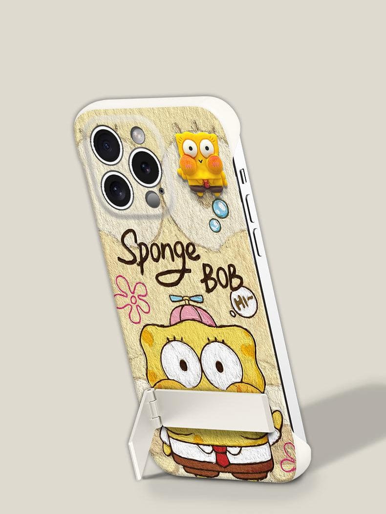 An iPhone 16 Pro Max Ultra-Thin Frameless Case in pink and yellow with a cartoon design, featuring Spongebob Squarepants' face, flowers, text, a small attached figurine, and an integrated foldable stand.