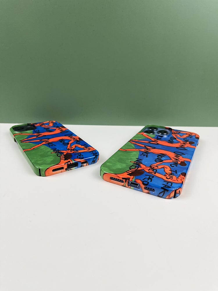 Two Vibrant Art Dance iPhone 16 Pro Max Cases - Bold Expression with Colorful Figures lie flat on a surface, featuring a vibrant and abstract design with blue, orange, and green hues. The cases are positioned at angles to each other against a green background.