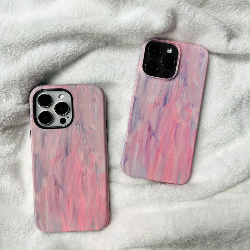 Two iPhones with Pastel Brushstrokes iPhone 16 Pro Max cases lie on a soft, white, textured blanket. The cases feature a mix of pastel hues in an artistic design, creating a gentle and soothing aesthetic while offering full protection.