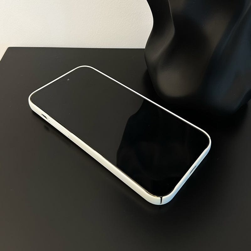 A sleek Minimalist Inspirational Quote iPhone 16 Pro Max case encloses a smartphone with a white frame and black screen, placed on a dark surface. A black abstract sculpture is partially visible in the background, adding an artistic touch.