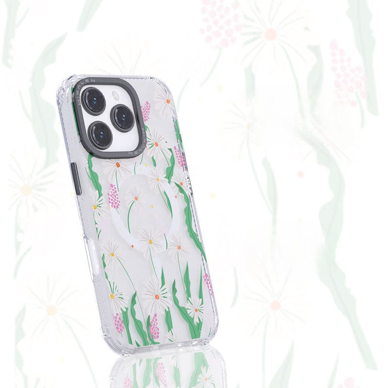 A smartphone with a Floral MagSafe iPhone 16 Pro Max Case featuring a 3D flower design with white flowers and green leaves is shown against a matching floral background. The clear, shockproof TPU + PC cover adds both style and protection.