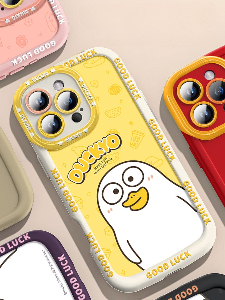 Close-up of several smartphone cases, predominantly featuring a cute yellow duck with “Good Luck” and “Ducky” written on the cases. The main case, an iPhone 16 Pro Max Yellow Duck Cartoon Case - Soft Liquid Silicone Protective Cover, showcases a white duck and offers shockproof phone protection; other cases are available in different colors.