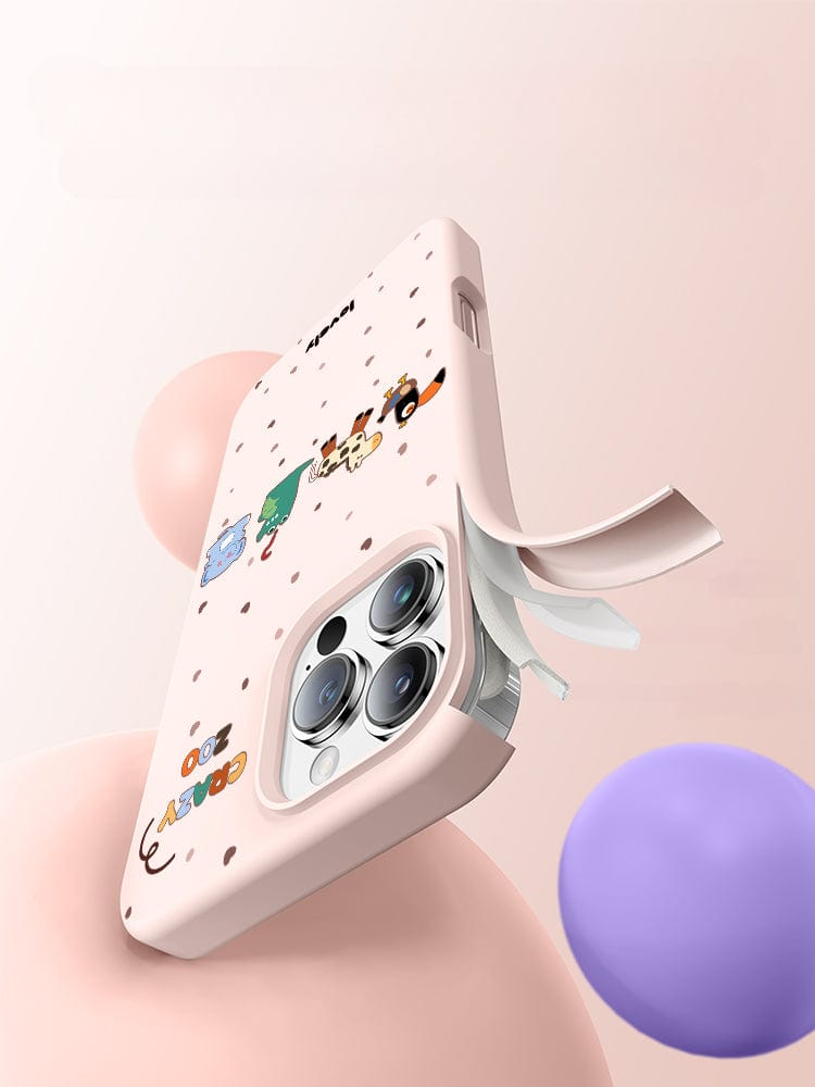 An iPhone 16 Pro Max adorned with a Crazy Zoo-themed liquid silicone case featuring cute animal designs, with three note sheets partially tucked into the back, captured against a soft, blurry background with pastel colors.