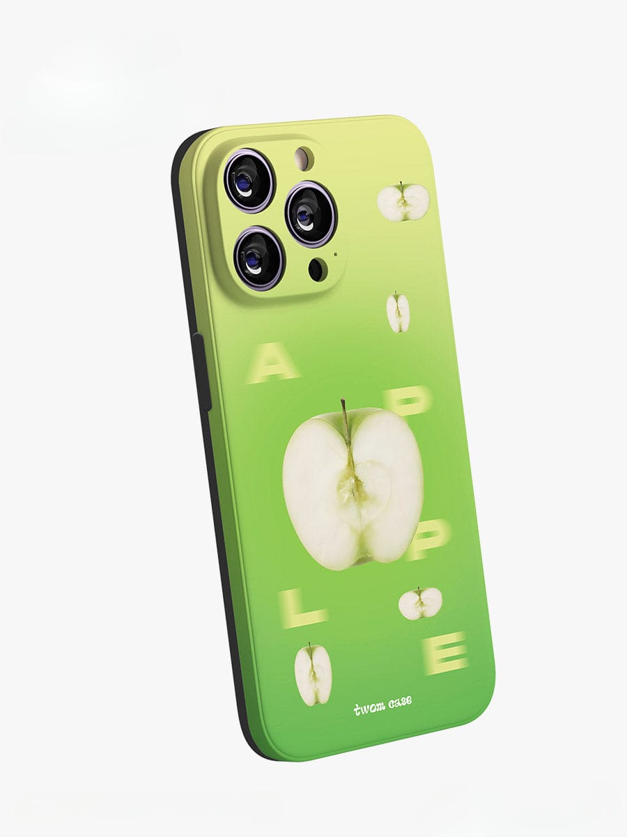 The Green Apple Fresh iPhone 16 Pro Max case, part of the Vibrant Gradient Design collection, features multiple images of green apples with the largest one centrally placed. The word "APPLE" appears in yellow, scattered in sections around the apples. Three camera lenses are visible on the upper left side of the phone within this playful all-inclusive protective cover.