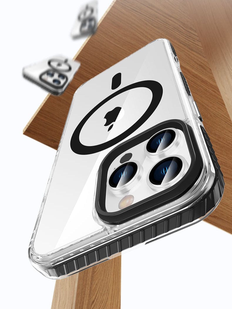 The iPhone 16 Pro Max Clear MagSafe Case - Shockproof with Air Cushion Corners, made of TPU+PC material with metal buttons, features a black circular design on the back that highlights the three rear camera lenses. It is displayed laying on a wooden surface with additional cases scattered in the background.