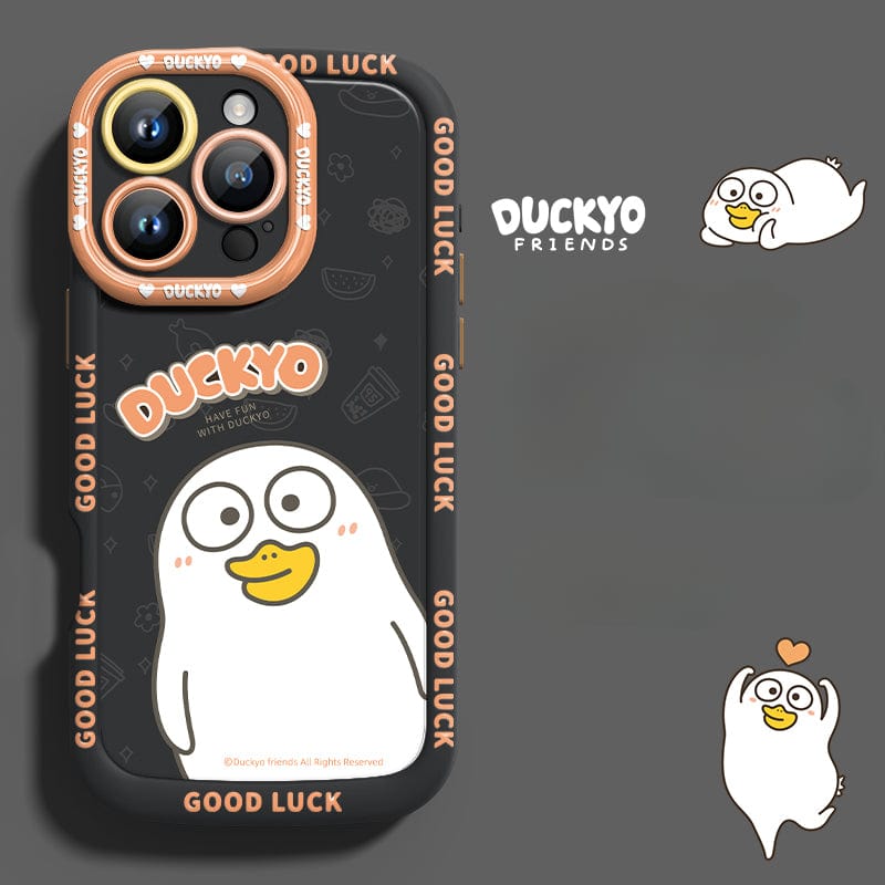 The iPhone 16 Pro Max Yellow Duck Cartoon Case is a soft liquid silicone protective cover featuring a cute yellow duck cartoon with the words "DUCKYO" and "GOOD LUCK" on it. The black background is accented with orange, complementing the design, while another illustration of the same duck and the text "DUCKYO FRIENDS" are also displayed nearby.