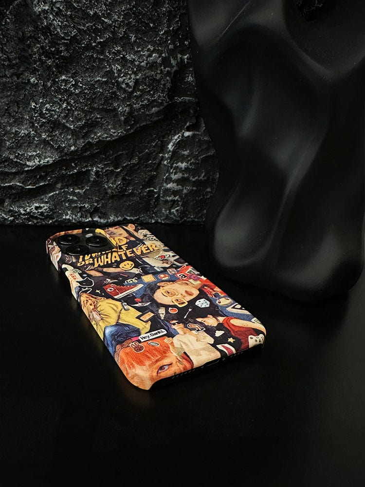 A smartphone enclosed in a Vibrant Collage iPhone 16 Pro Max Case, adorned with pop art, street style, and retro design elements, lies on a black surface next to a modern, abstract black sculpture against a textured, dark background.