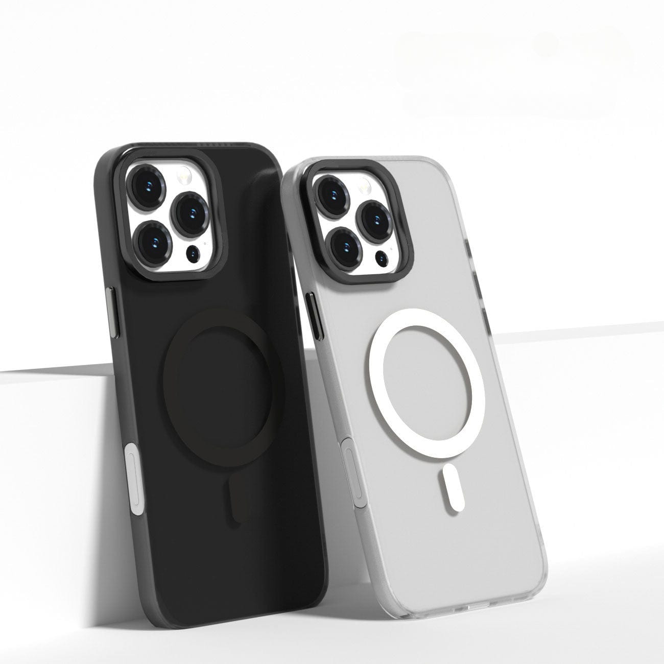 Two smartphones with triple-lens cameras are positioned side by side on a white surface. One phone dons a black case, while the other features an iPhone 16 Pro Max Clear Case with MagSafe, both made from scratch-resistant material and showcasing circular designs on the back.