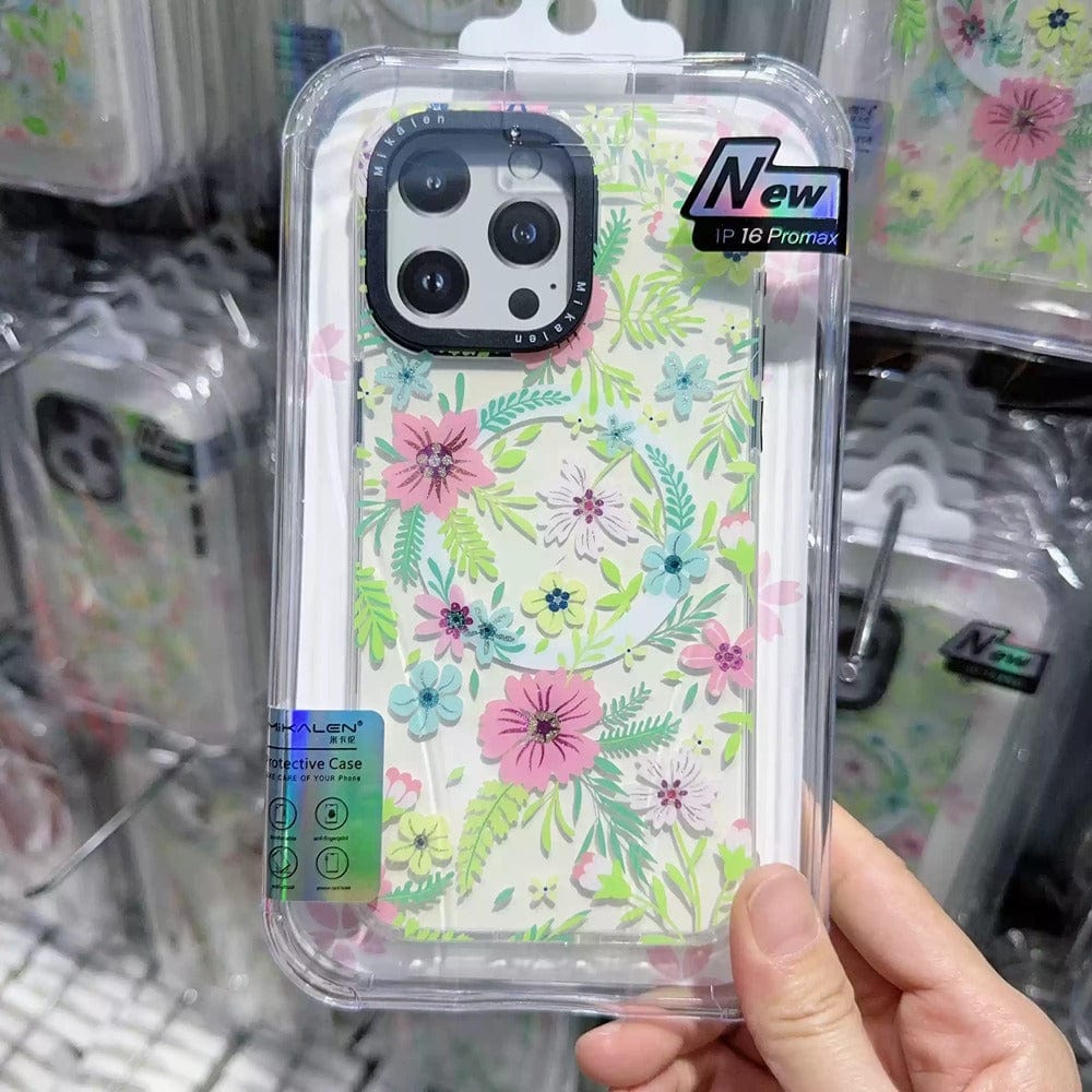 A person holds the Floral MagSafe iPhone 16 Pro Max Case, showcasing a 3D flower design with pink and blue flowers accompanied by green leaves. This case combines style and shockproof protection within its TPU + PC protective shell, elegantly packaged in a clear cover.