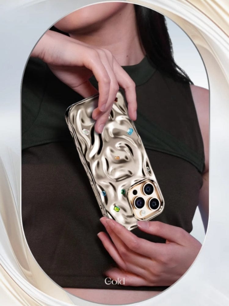 A person holds a gold smartphone featuring a wavy, textured surface with multiple camera lenses, encased in an iPhone 16 Pro Max Luxury Case with N52 Magnets, made from PC material and showcasing a handcrafted gemstone design.