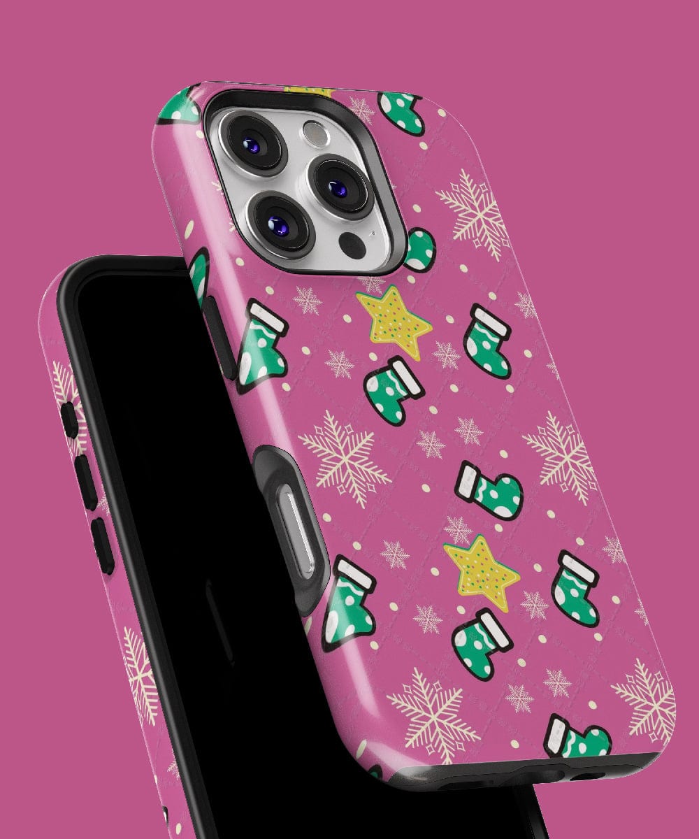 The Festive Stocking iPhone 16 Pro Max Case in a pink holiday design adorned with green mittens, yellow stars, and white snowflakes perfectly embodies the festive spirit. This case is MagSafe Compatible.