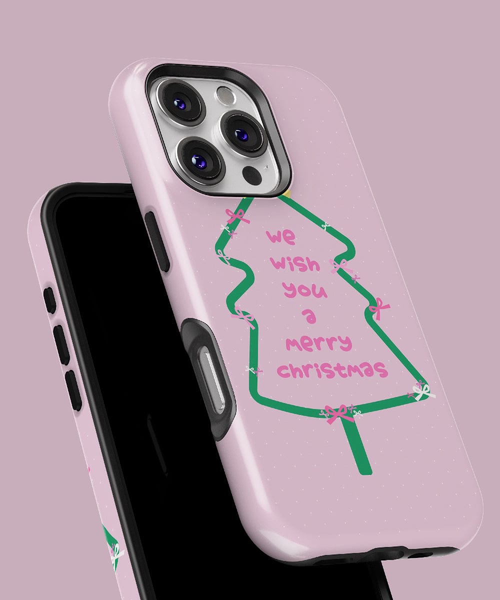 Merry Christmas Tree iPhone 16 Pro Max Case – Festive Pink & Green Design, showcasing a light pink background with a charming Christmas tree and the phrase "we wish you a merry Christmas" in pink lettering. This MagSafe-compatible case combines holiday cheer with dual-layer protection for enhanced durability.