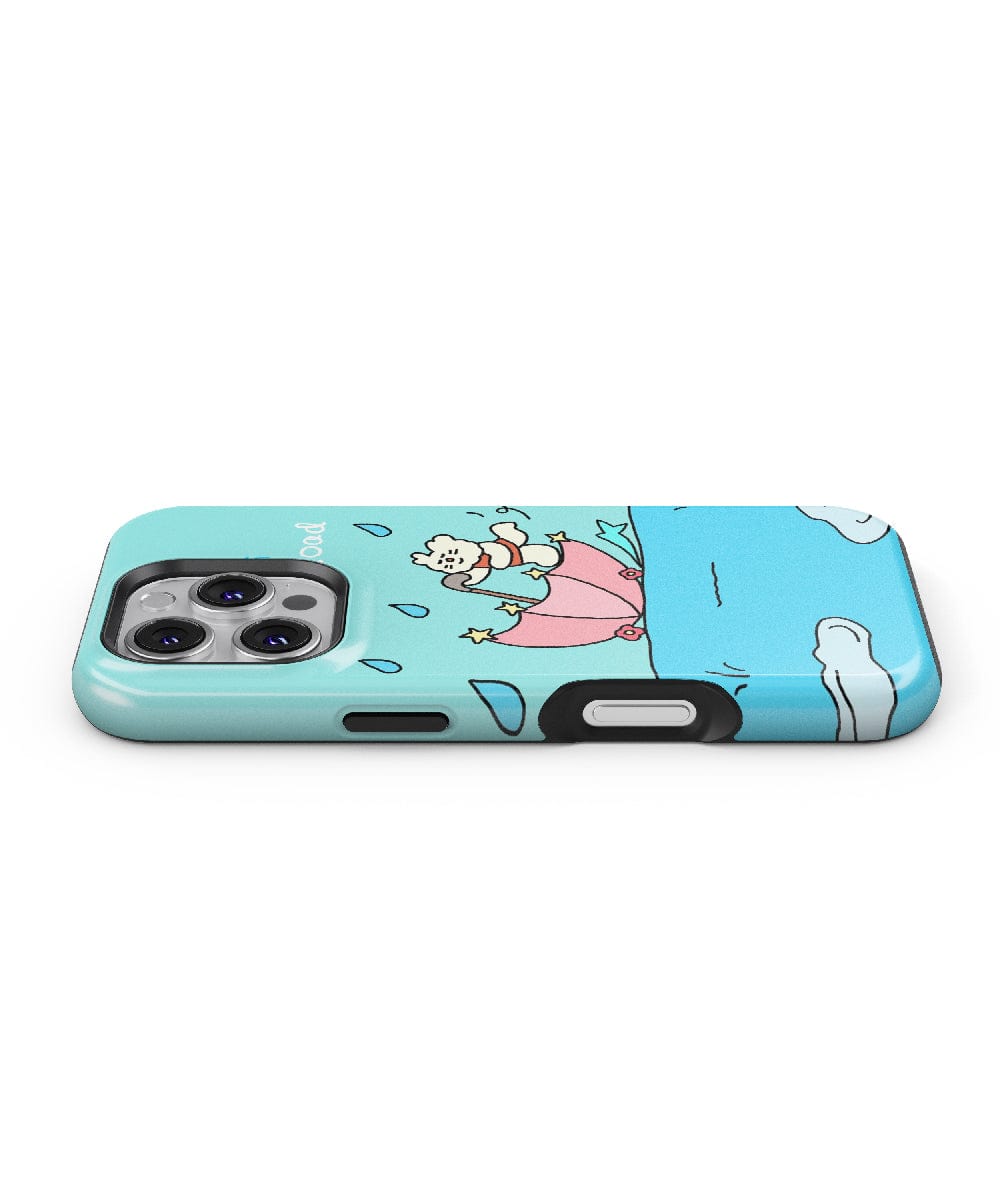 The Cute Bear with Umbrella iPhone 16 Pro Max Case is a light blue, MagSafe-compatible phone case featuring a cartoon character driving a pink car with stairs in the background while being pelted by food items. The back camera and volume buttons of the phone are visible. Enjoy added shockproof protection for your device with its slim fit PC + silicone design!